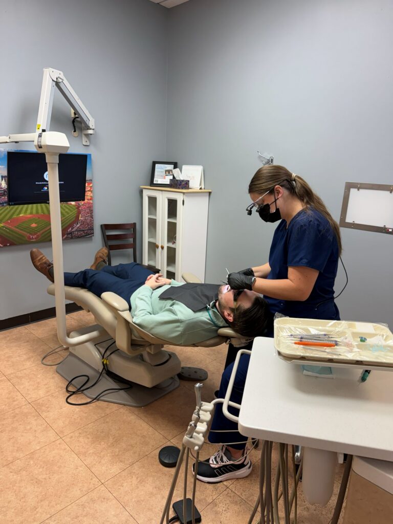 Dentist and assistant treating patient in St. Charles MO dental office